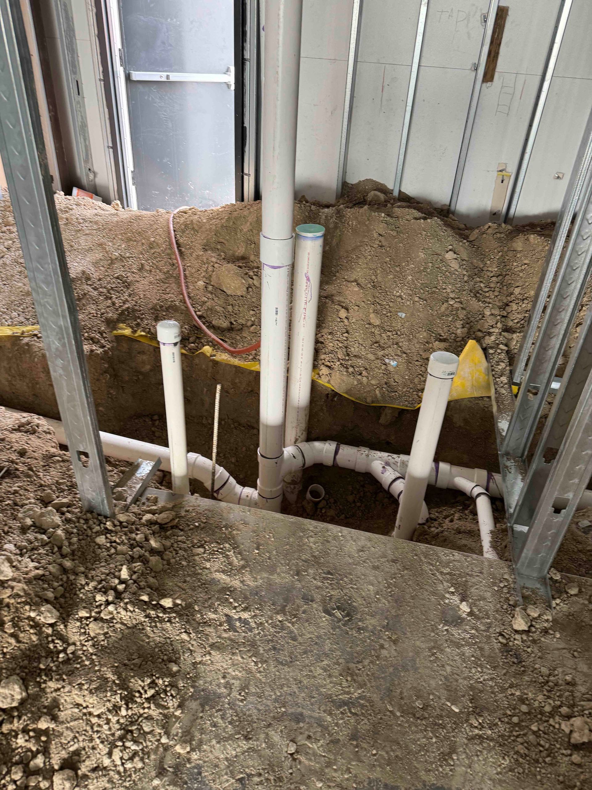 A bunch of pipes are being installed in a hole in the ground.