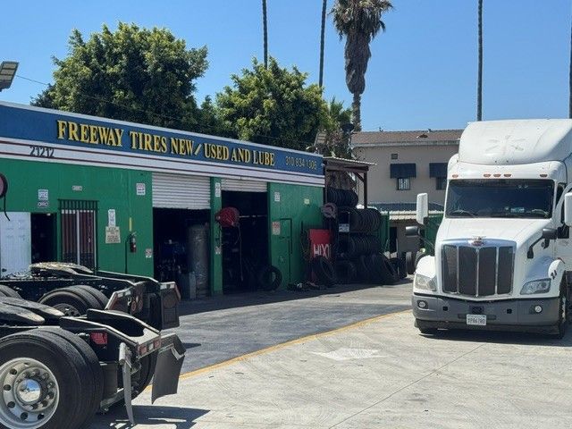 Freeman Tires shop with a white semi-truck parked outside on a sunny street