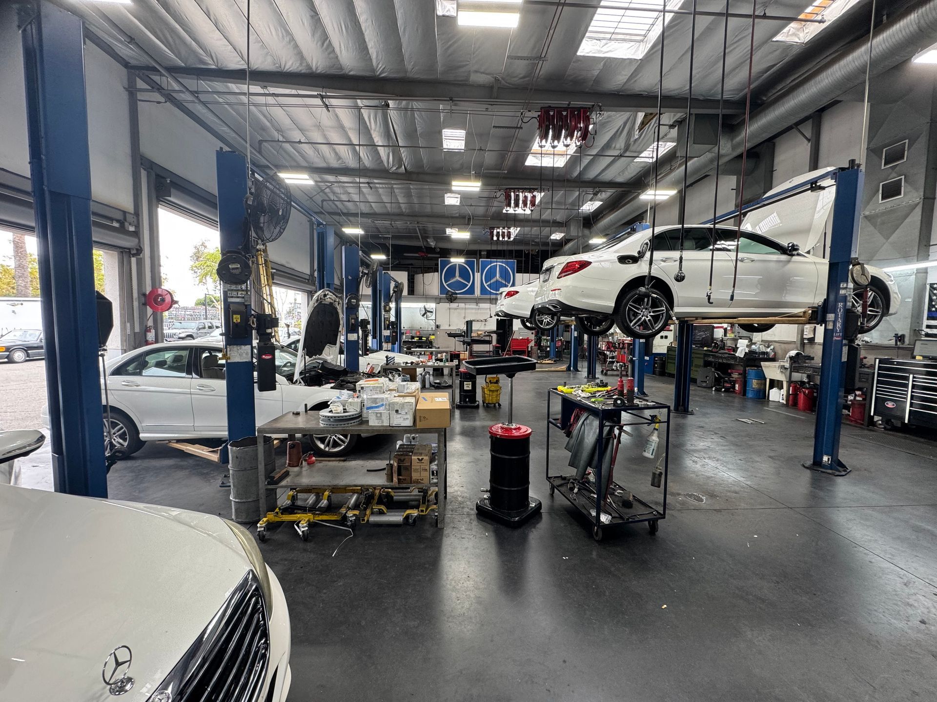 Auto repair shop with cars on lifts, tools, and bright industrial lighting