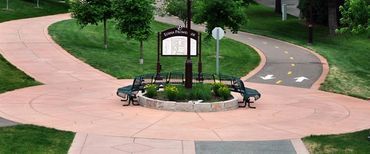 A circular walkway in a park with a sign in the middle.