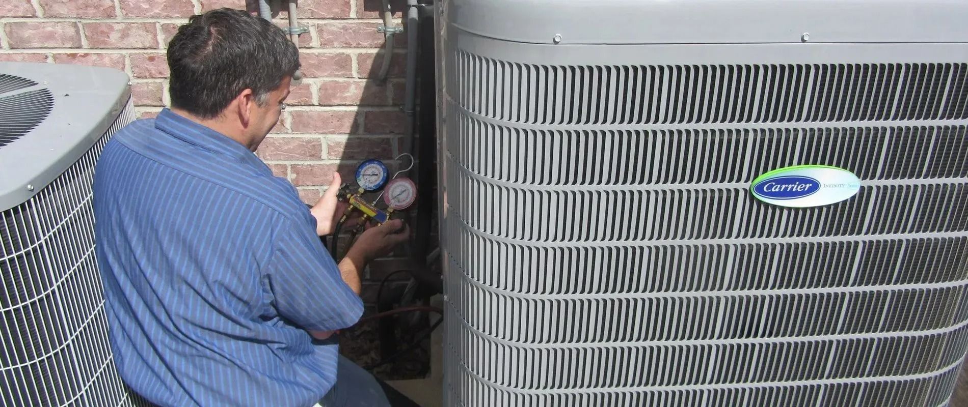 Plumber showing a woman a kitchen sink with a wrench, smiling. Inside the cabinet.