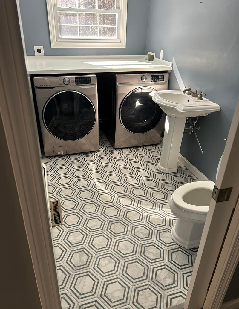 A laundry room with a washer, dryer, sink and toilet