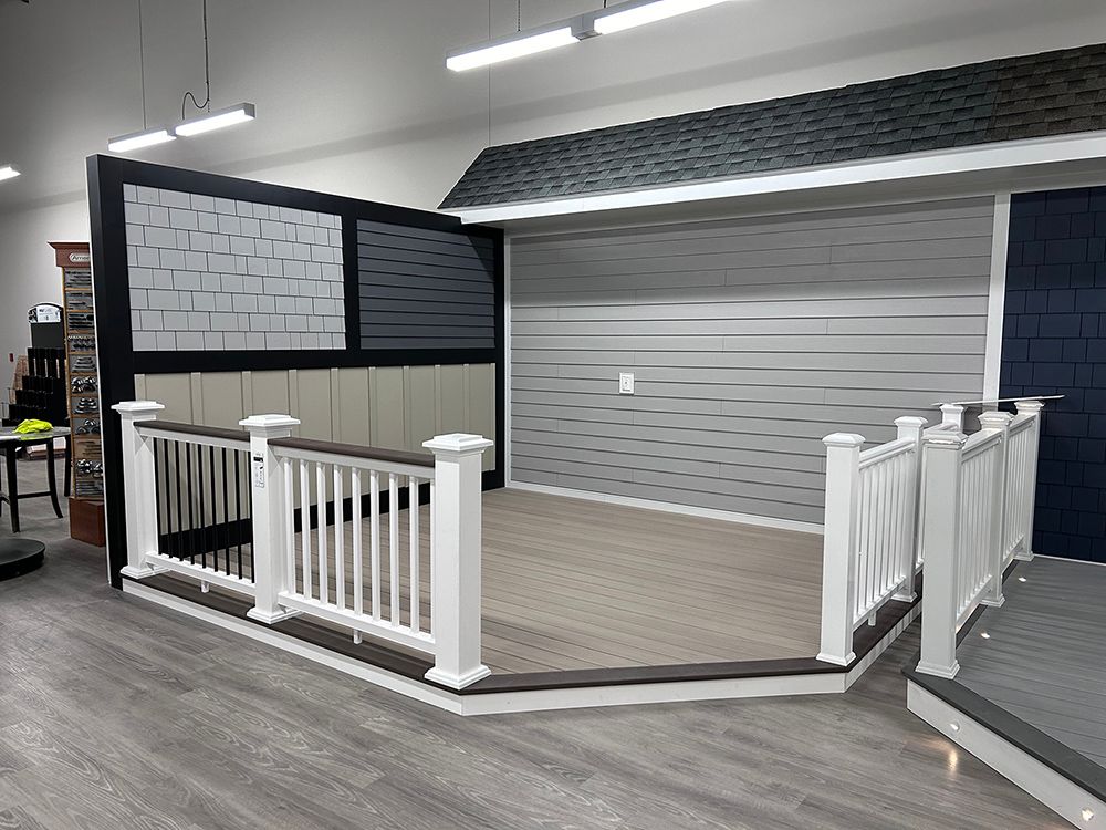 A showroom with a patio and a white railing in it