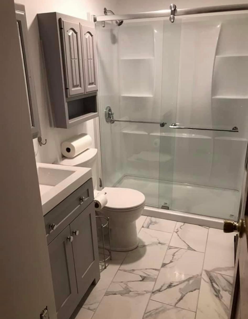 A bathroom with a toilet, sink, and shower