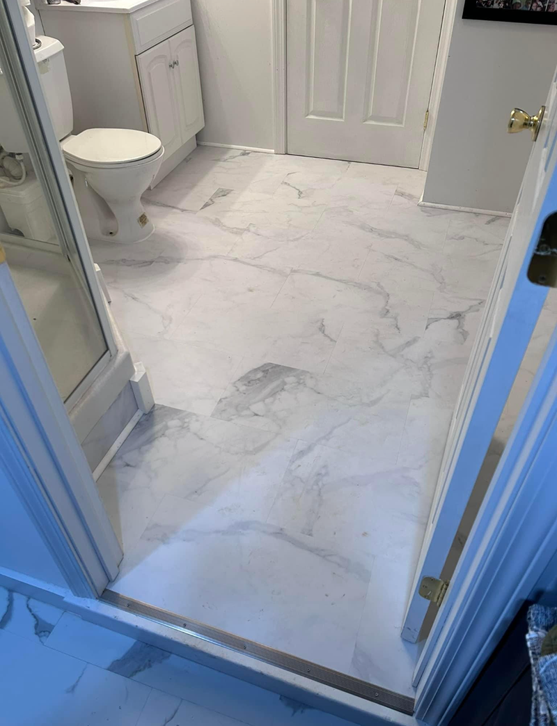 A bathroom with a toilet, sink and marble floor