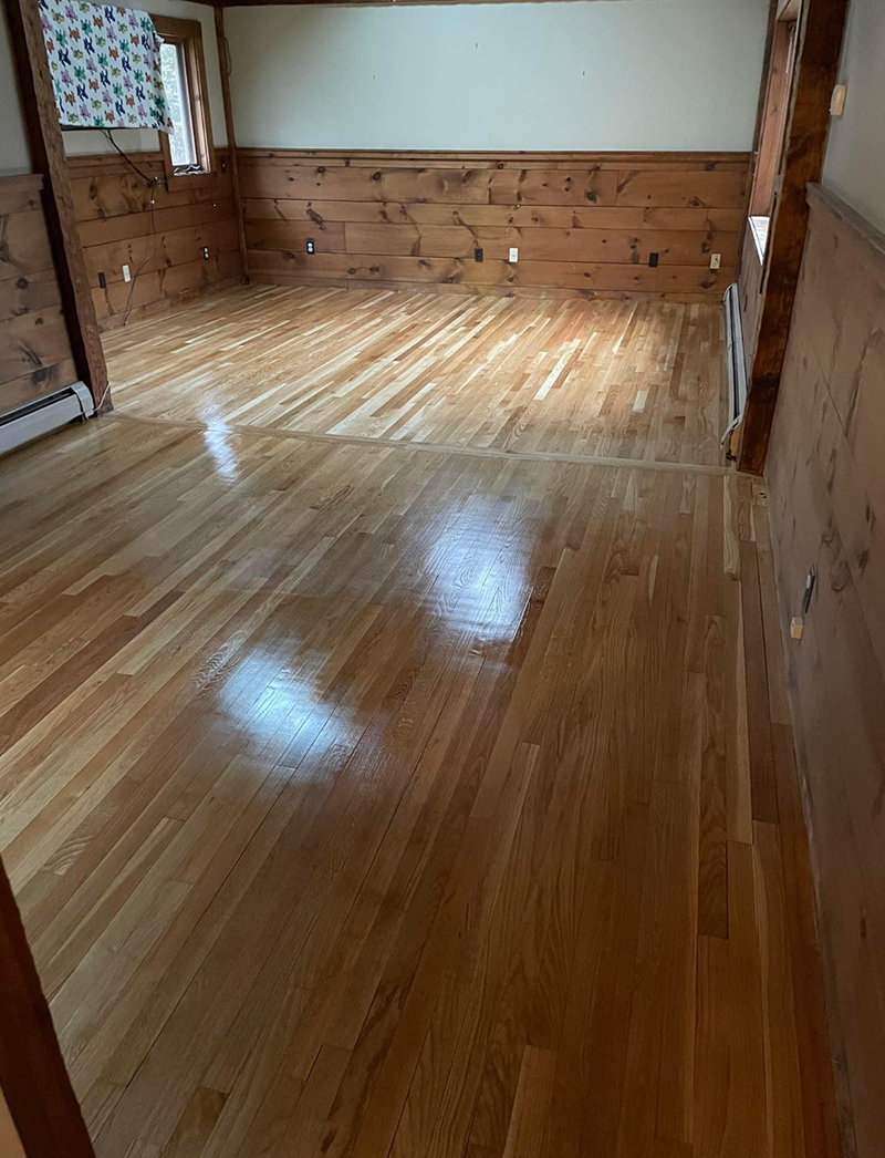 A living room with hardwood floors and wooden walls