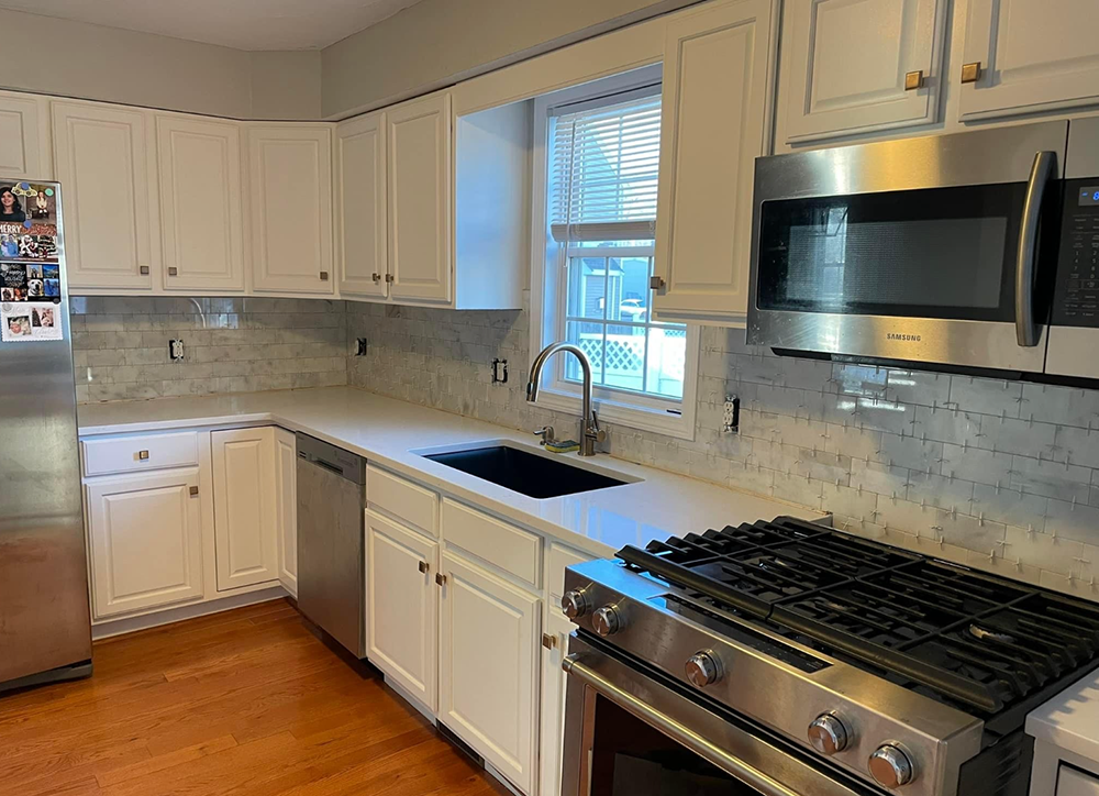 A kitchen with stainless steel appliances and white cabinets