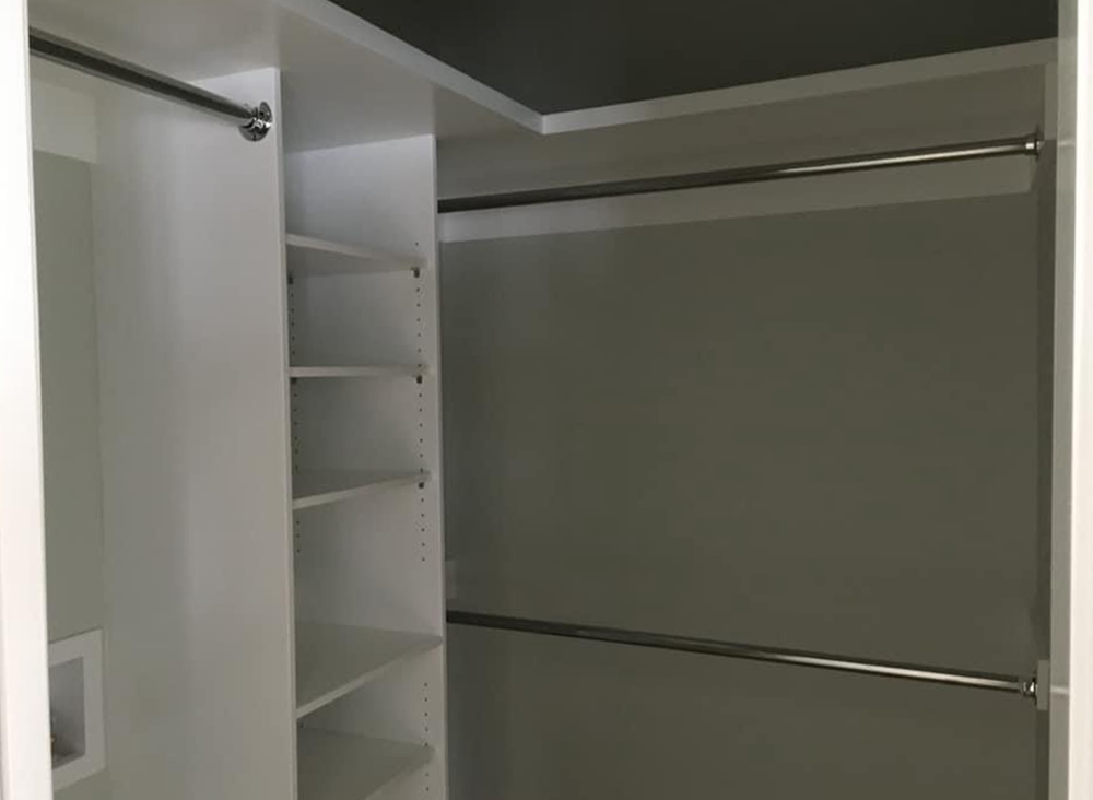 A walk in closet with shelves and a hanging rail