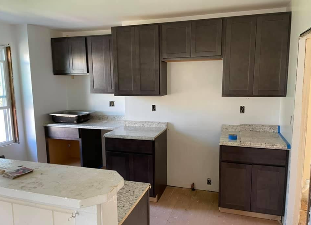 A kitchen with cabinets and white counter tops is being remodeled
