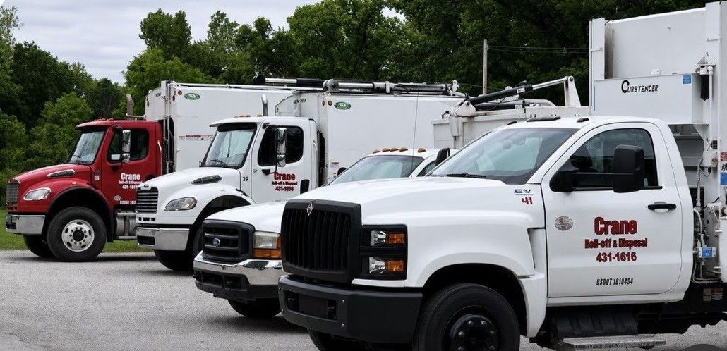 Work trucks parked in a lot, including white and red service vehicles.