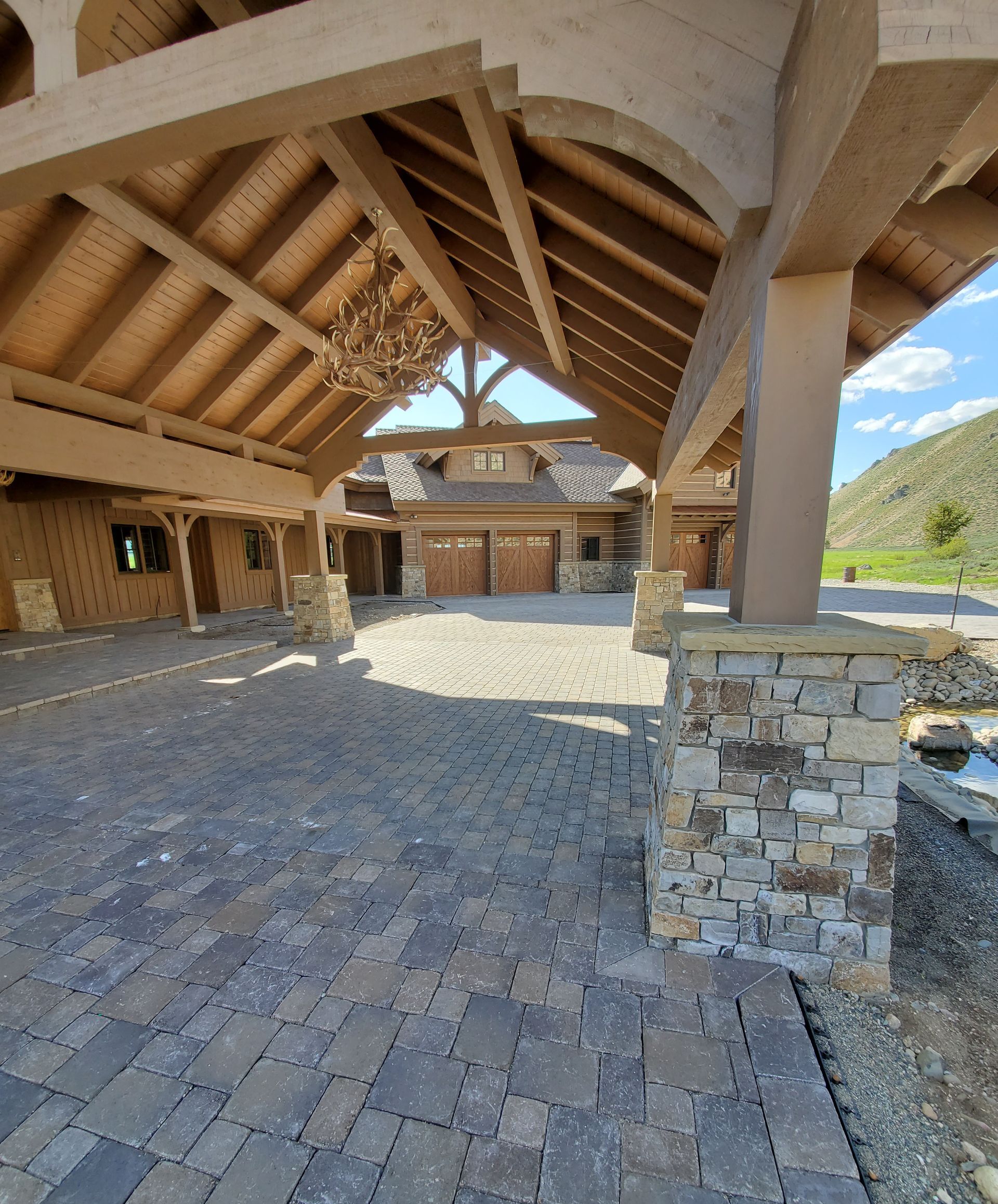 A large house with a wooden roof and a brick driveway