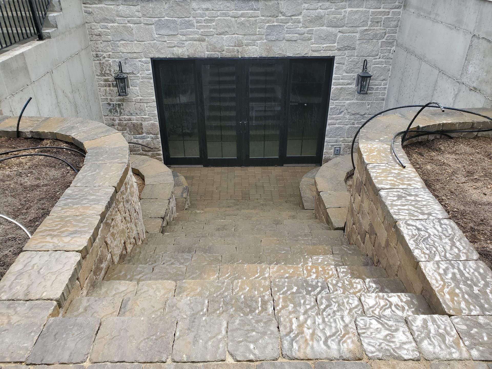 A stone wall with stairs leading up to a doorway.