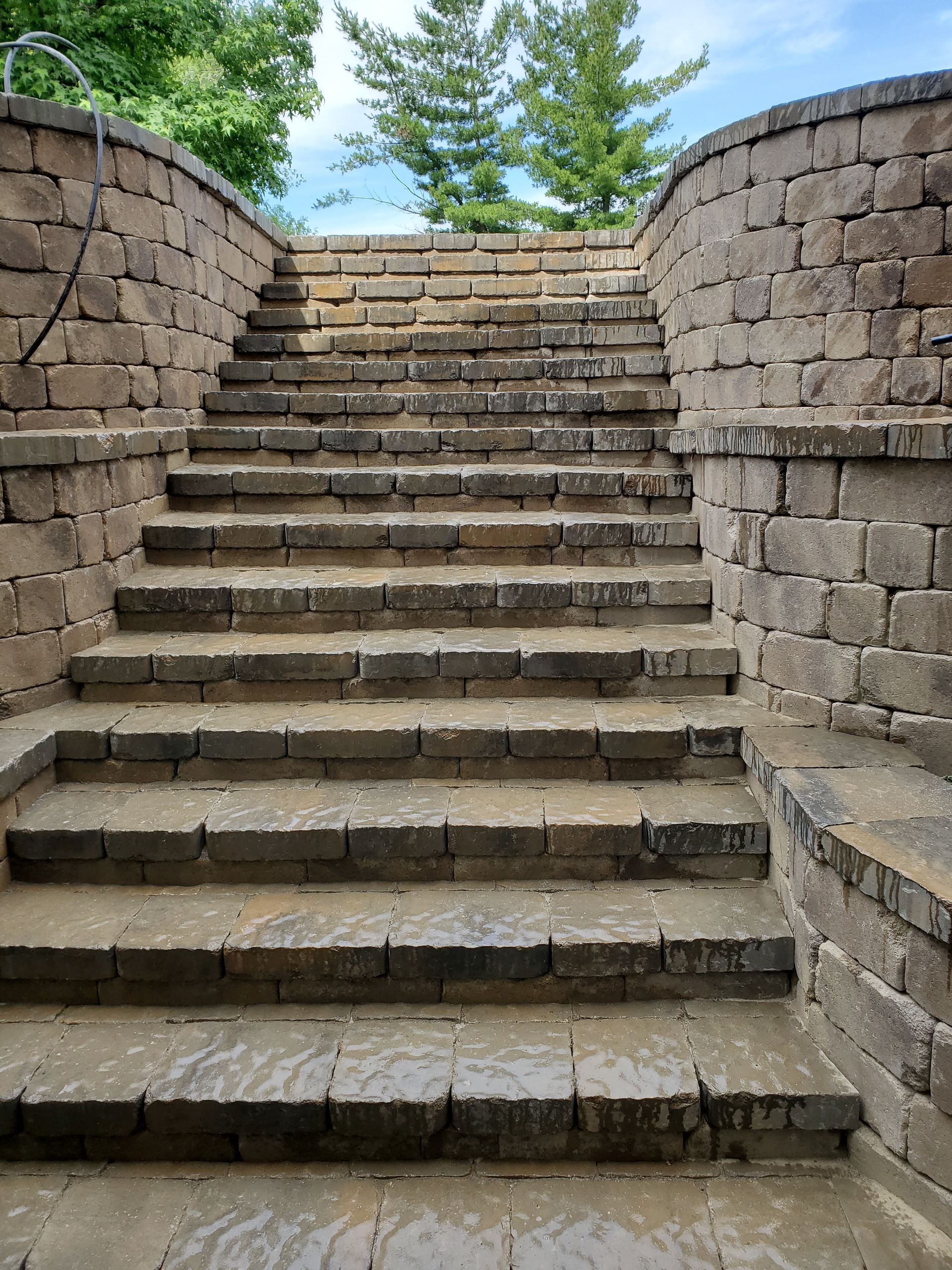 A set of stone stairs leading up to a stone wall.