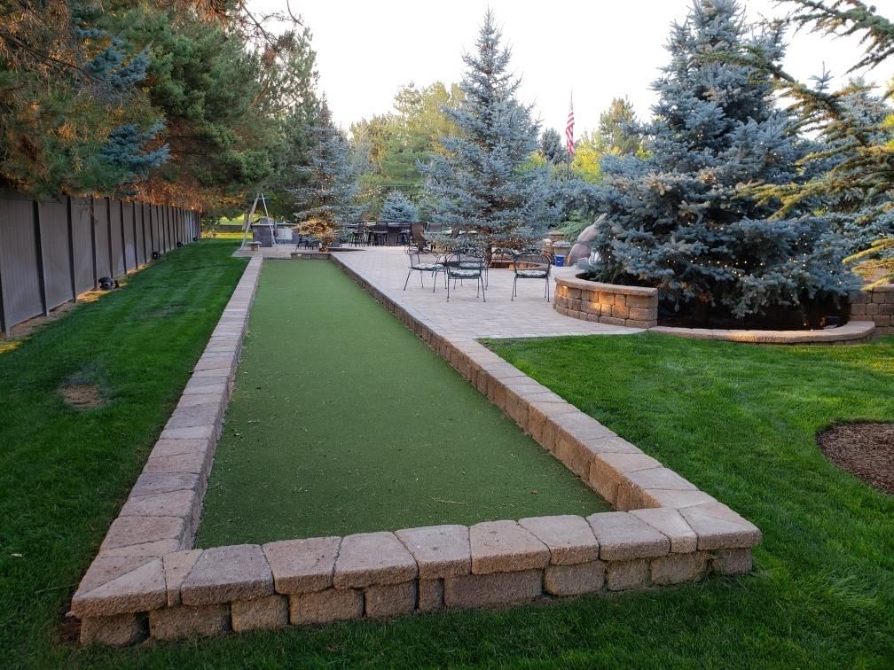 There is a bocce ball court in the middle of the yard.