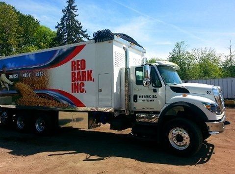 White Red Bark Inc. dump truck parked on a sunny day.