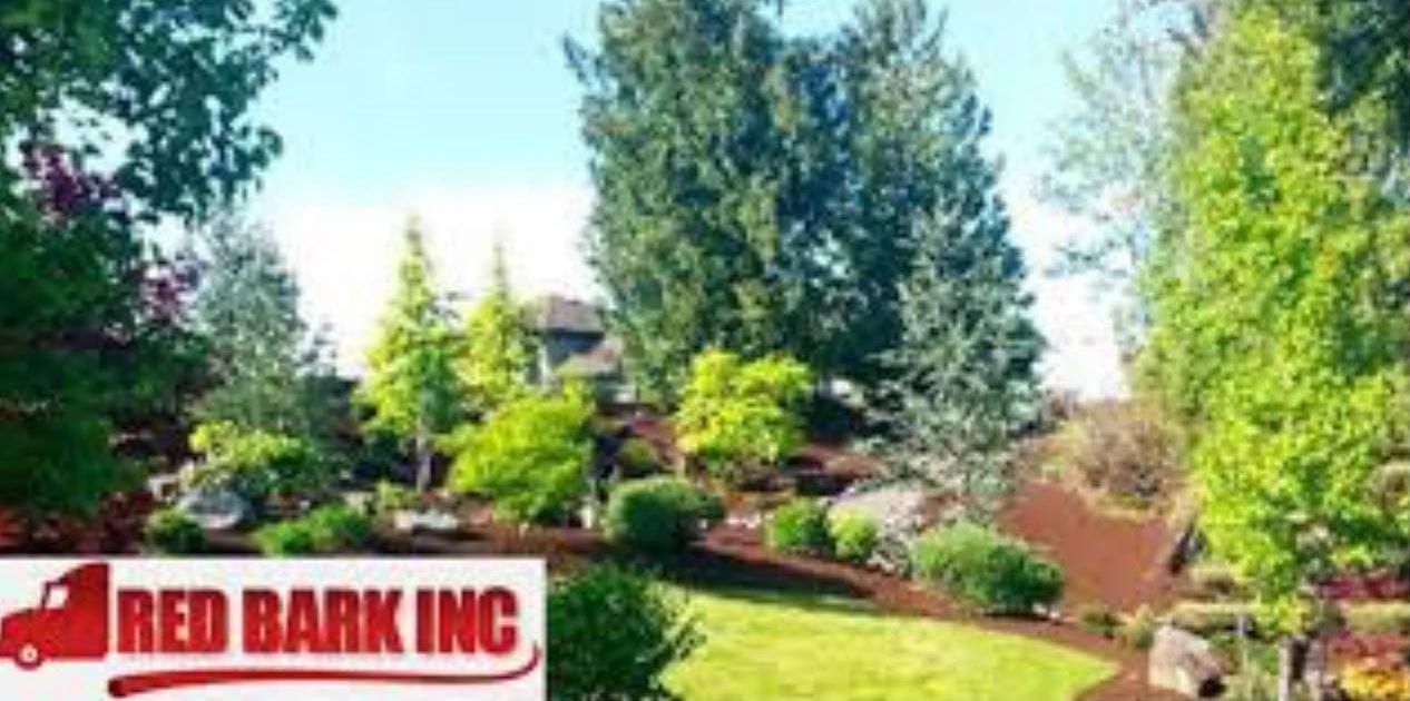 A landscaped yard with trees, bushes, and green grass. A red truck logo 