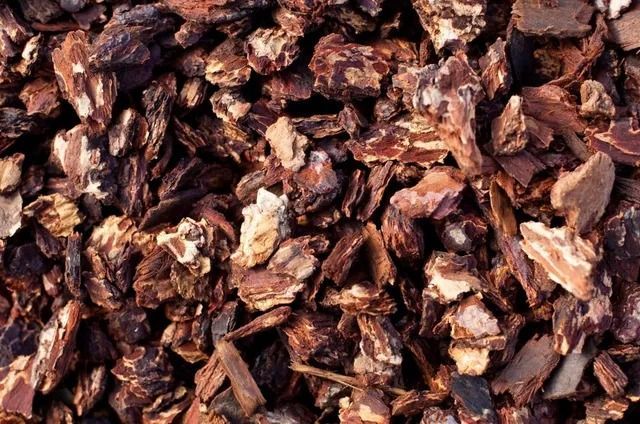 Brown bark mulch, with various-sized pieces and shades of brown and tan.