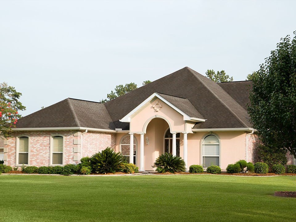 A large house with a lush green lawn in front of it.