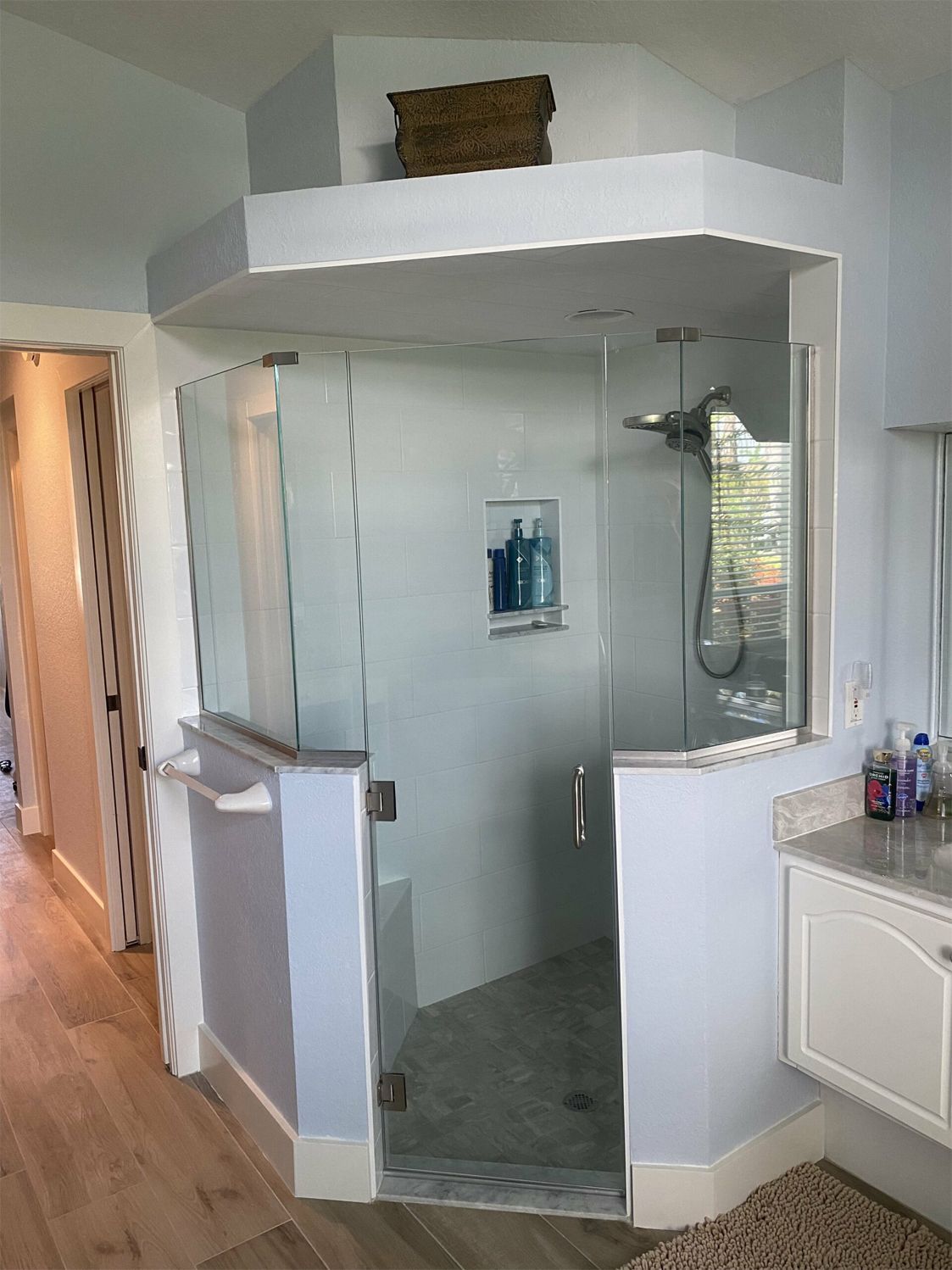 A bathroom with a walk in shower and a sink