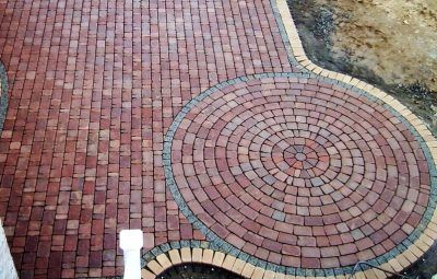 Brick patio with circular pattern and border.