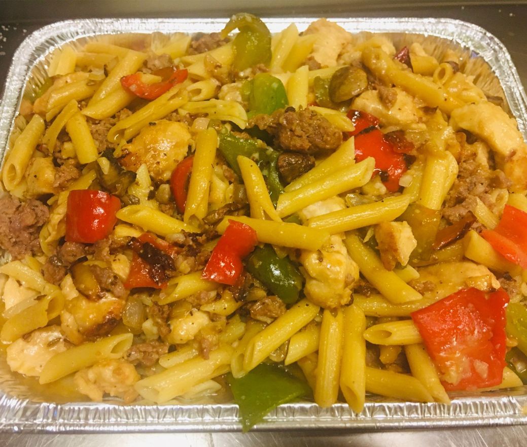 Tray of penne pasta with ground meat, peppers, and sauce in a foil container