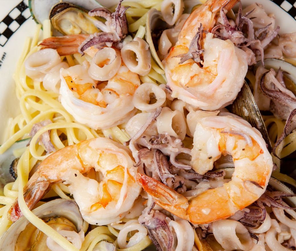 Shrimp and squid pasta with spaghetti in a white bowl