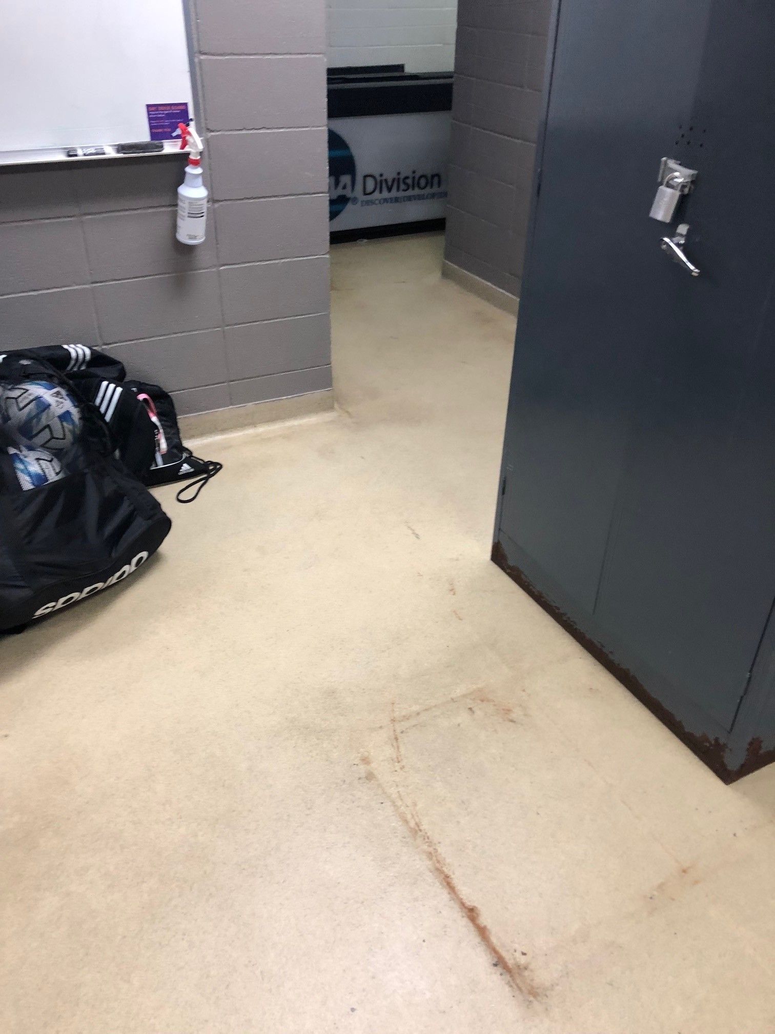 A room with a dirty floor and a bag on the floor.