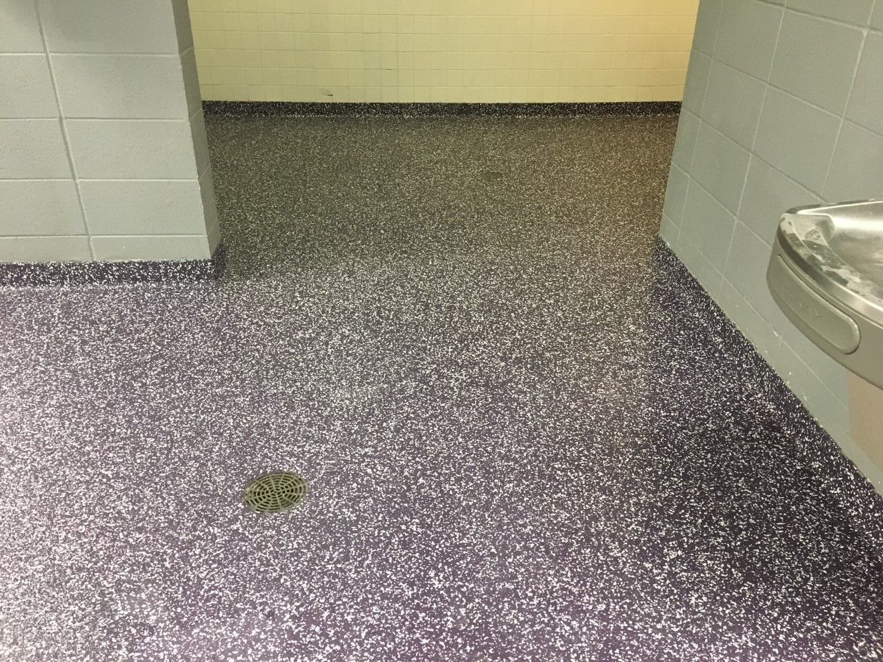 A bathroom with a purple floor and a sink.