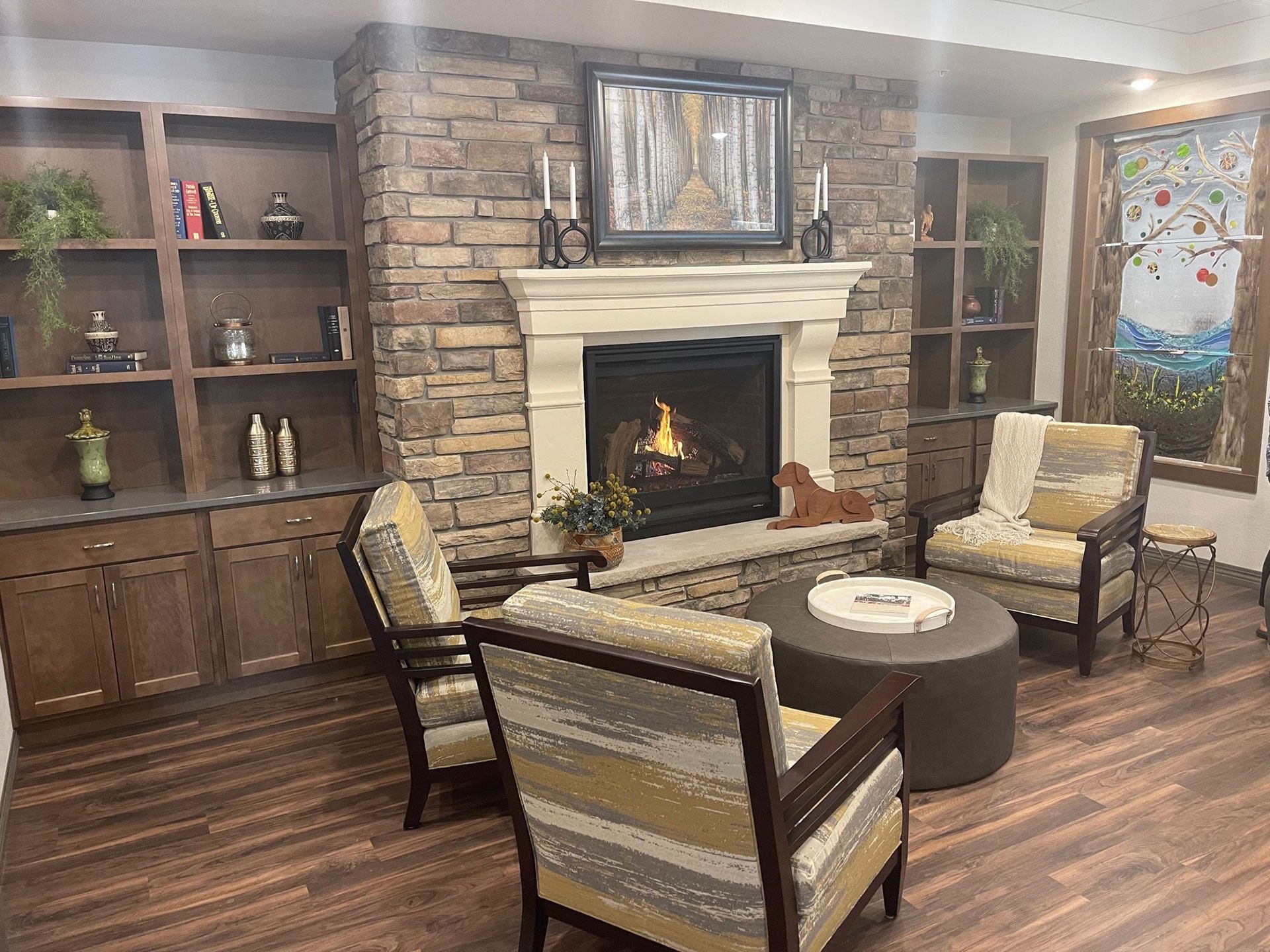 A living room with a fireplace , chairs , and a table.