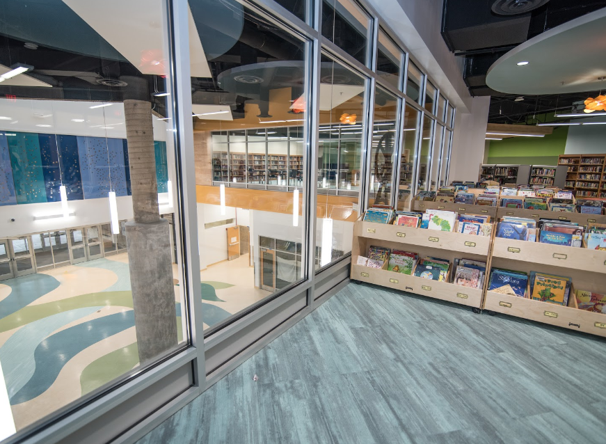 A library with a lot of windows and books on shelves.