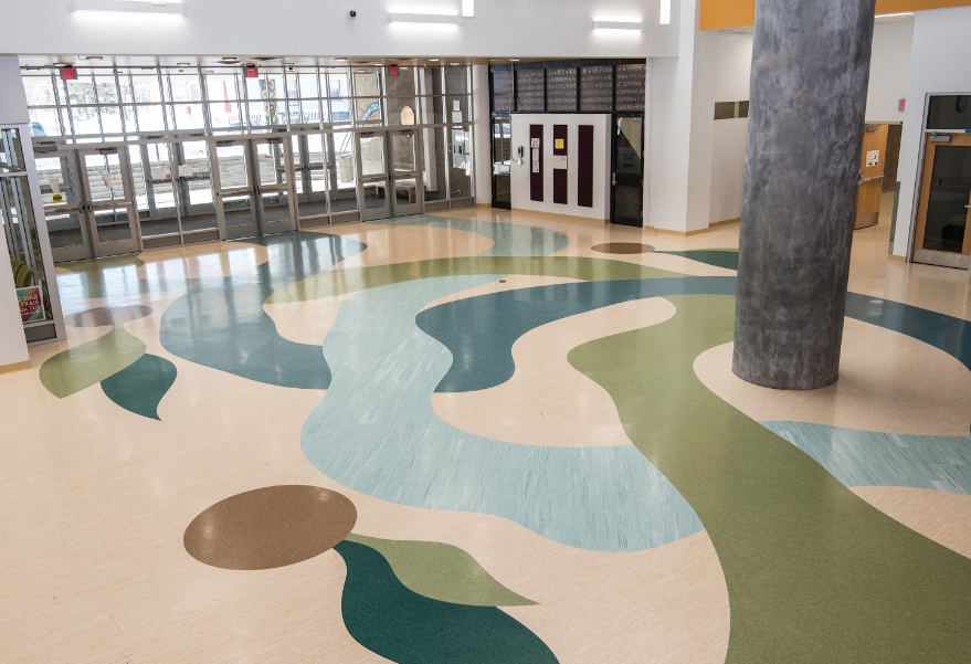 A large room with a colorful floor and a pillar in the middle.