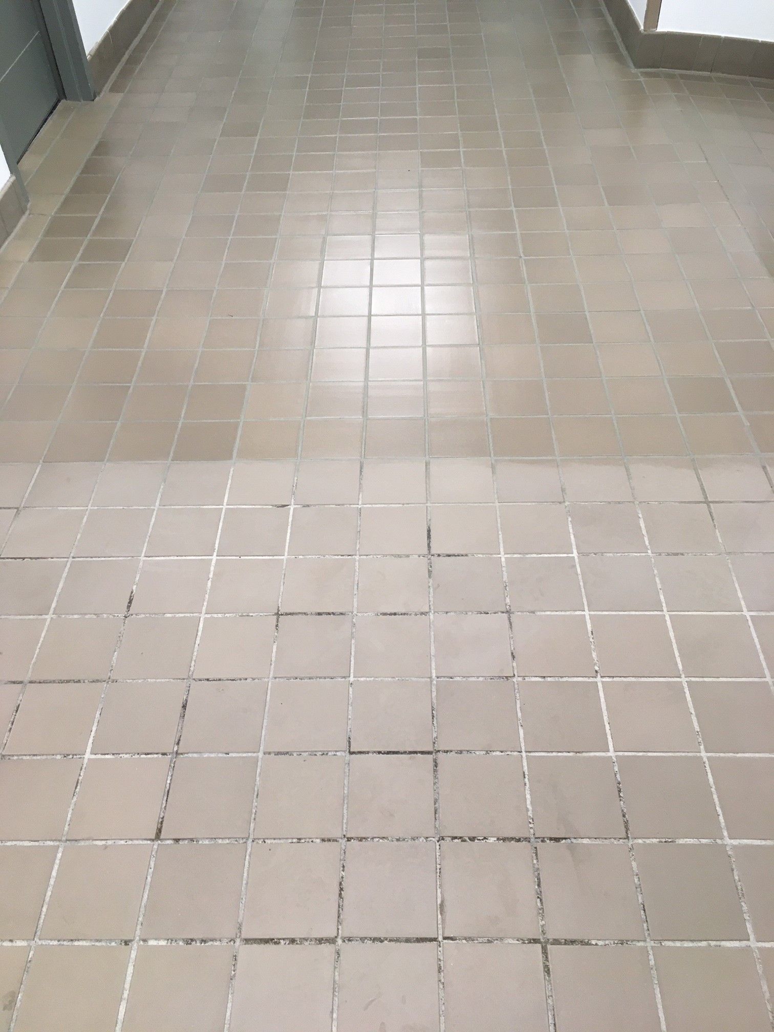 A hallway with a tile floor and a tile border.