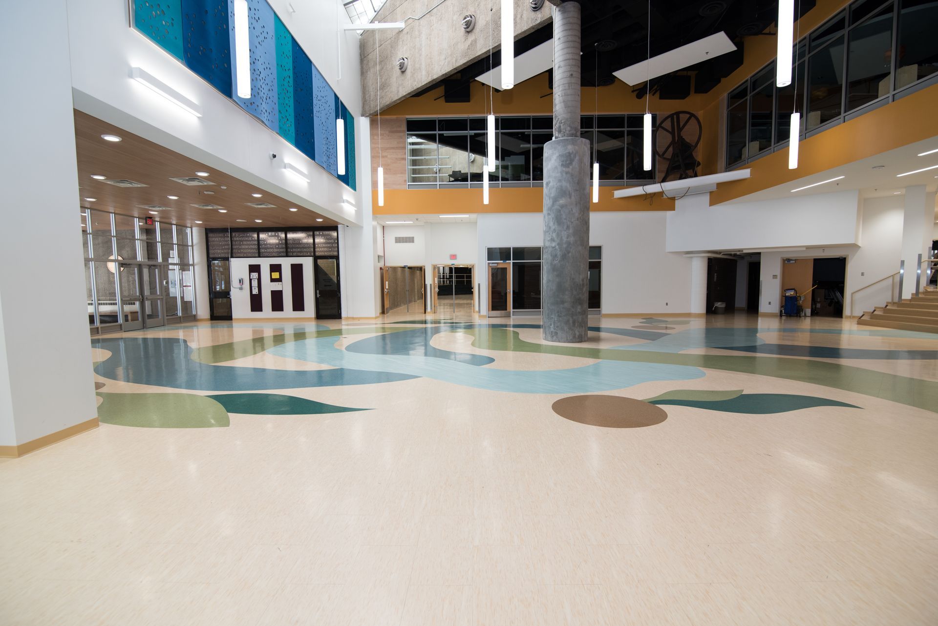 A large empty lobby in a building with a colorful floor.