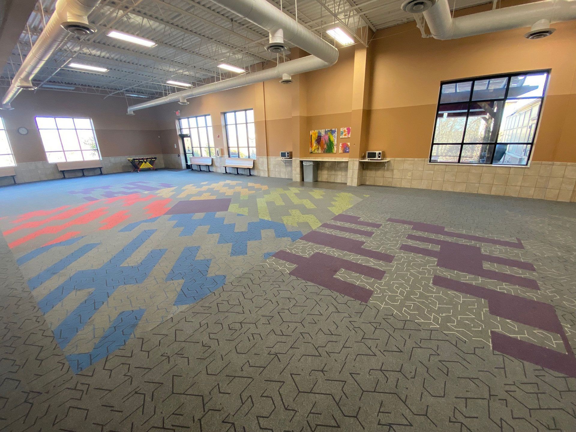 A large room with a lot of windows and a colorful carpet