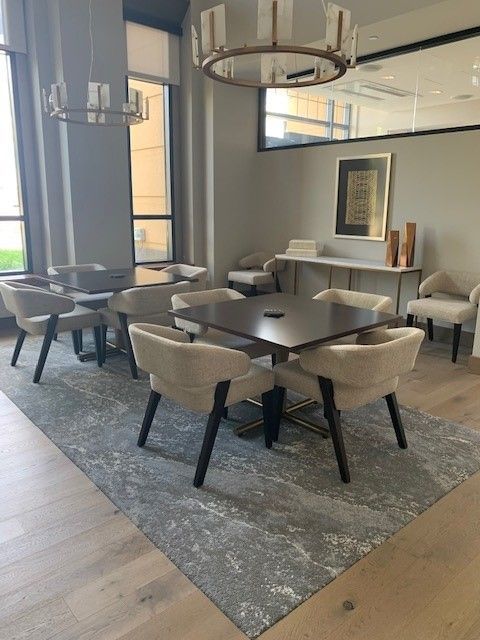 A dining room with tables and chairs and a chandelier hanging from the ceiling.