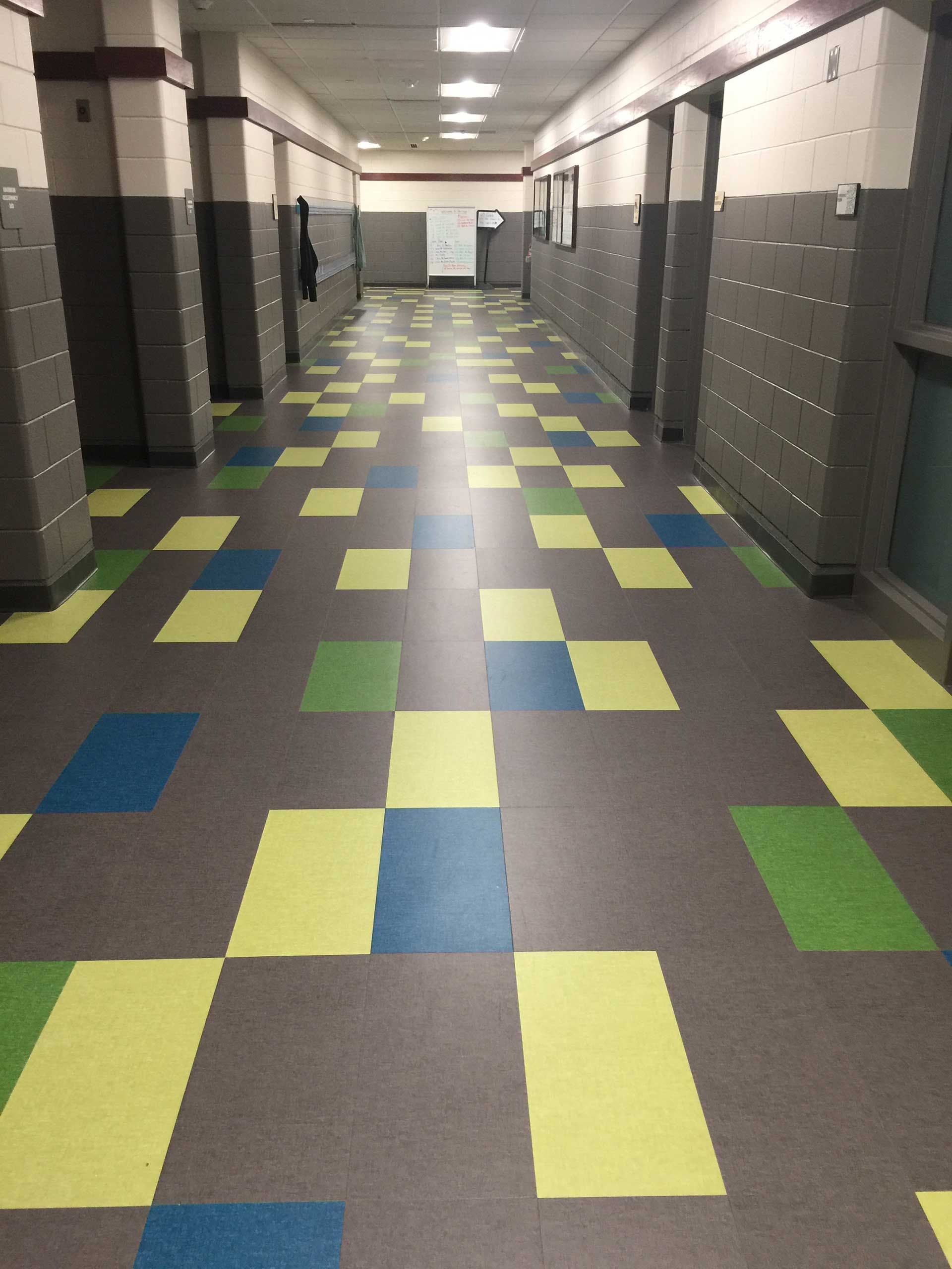 A long hallway with colorful tiles on the floor