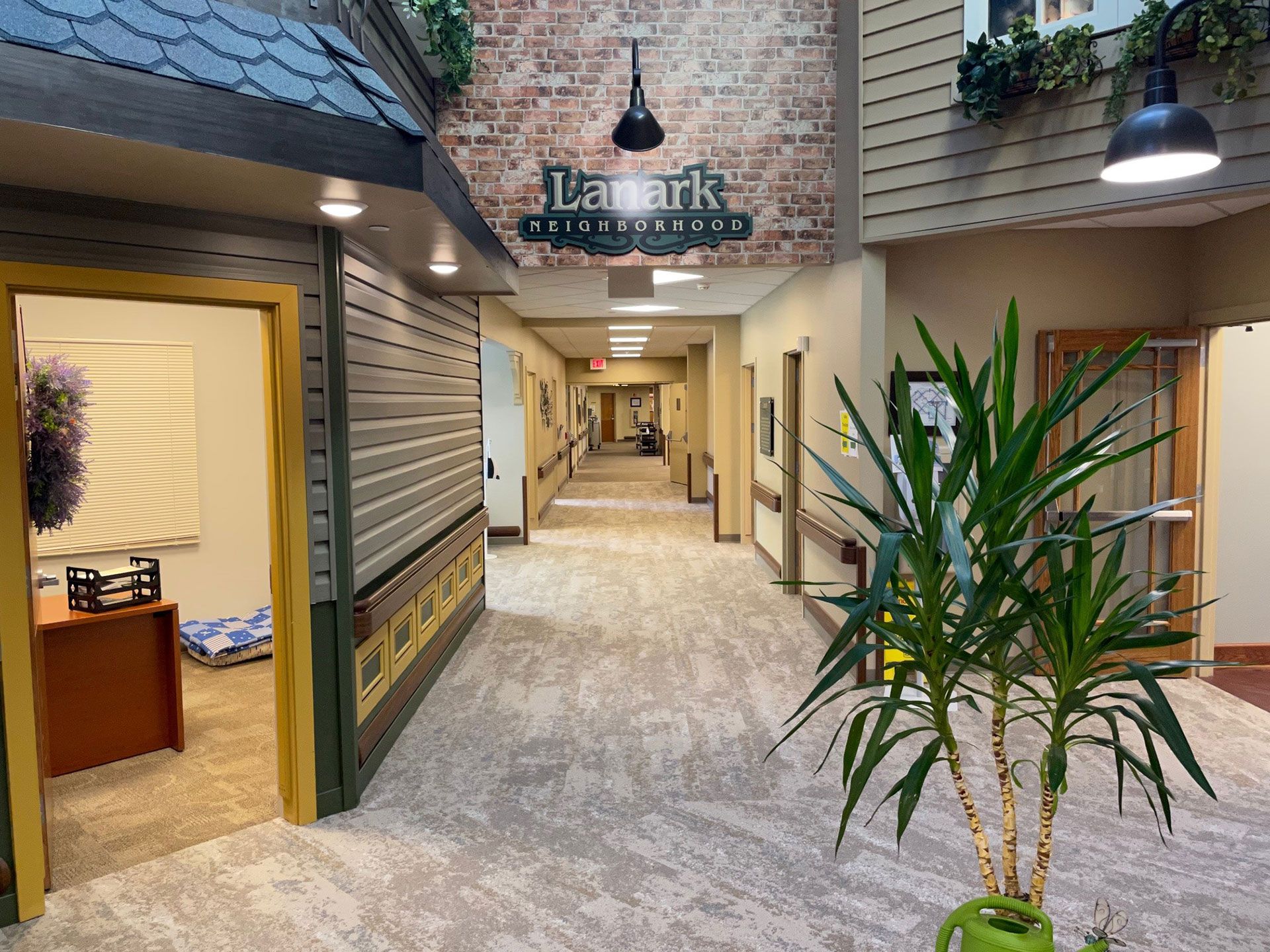A long hallway in a building with a plant in the middle.