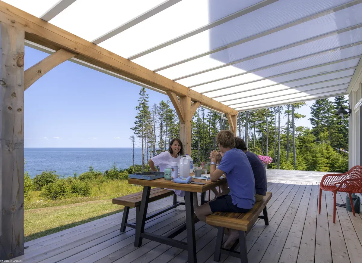 Family dining beneath a Sunspace acrylic patio cover