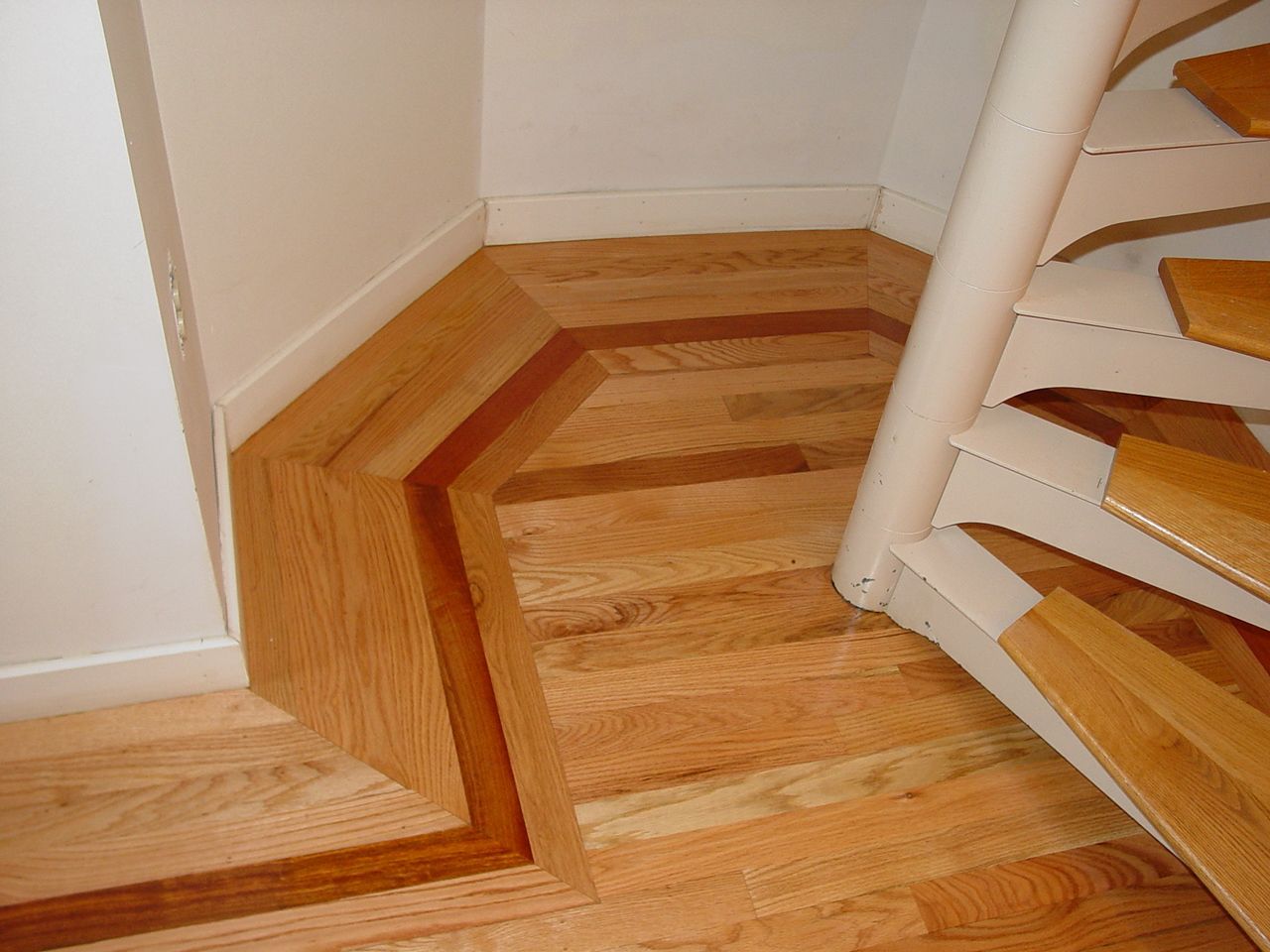 A spiral staircase with wooden steps and a white railing