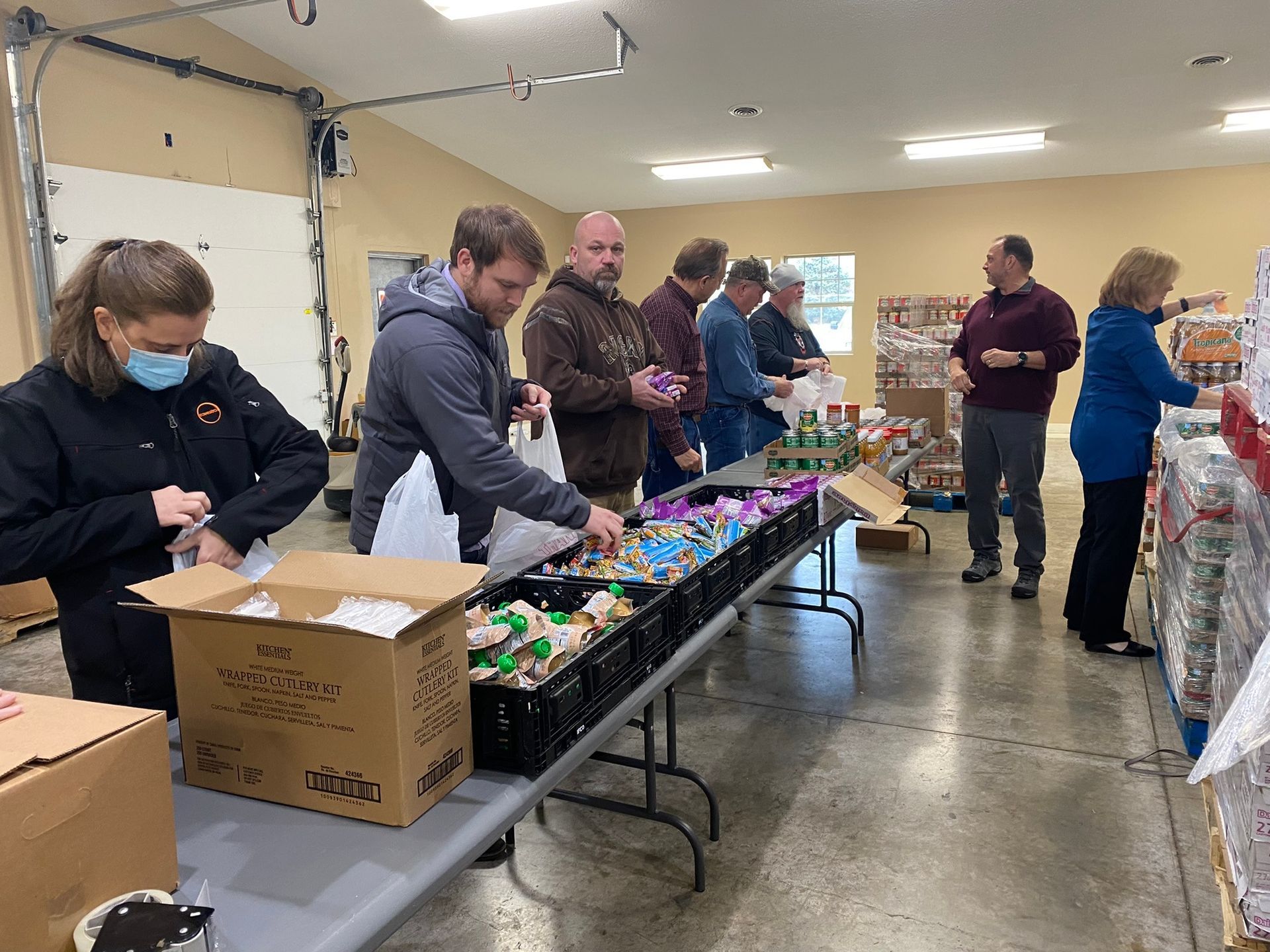 A group of people are standing around a table in a room.