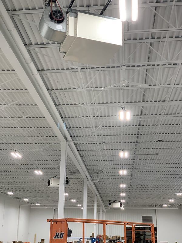 A large warehouse with a ceiling fan hanging from it