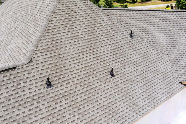 Gray shingled roof with three black vent pipes, seen from above