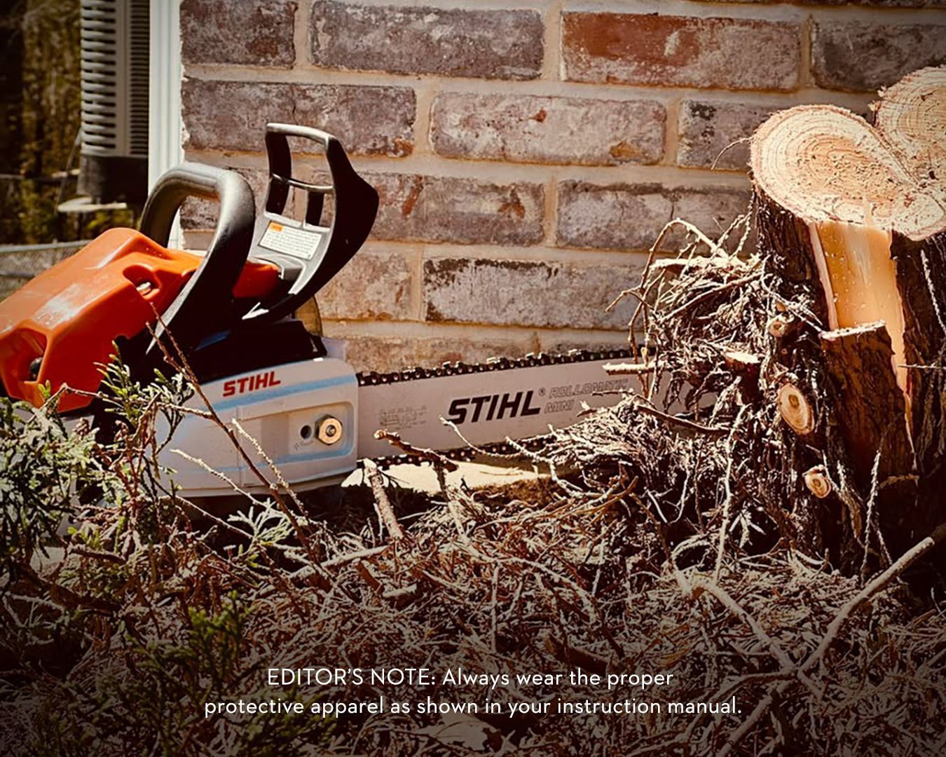 A chainsaw rests near a brick wall and a tree stump, promoting safety gear.