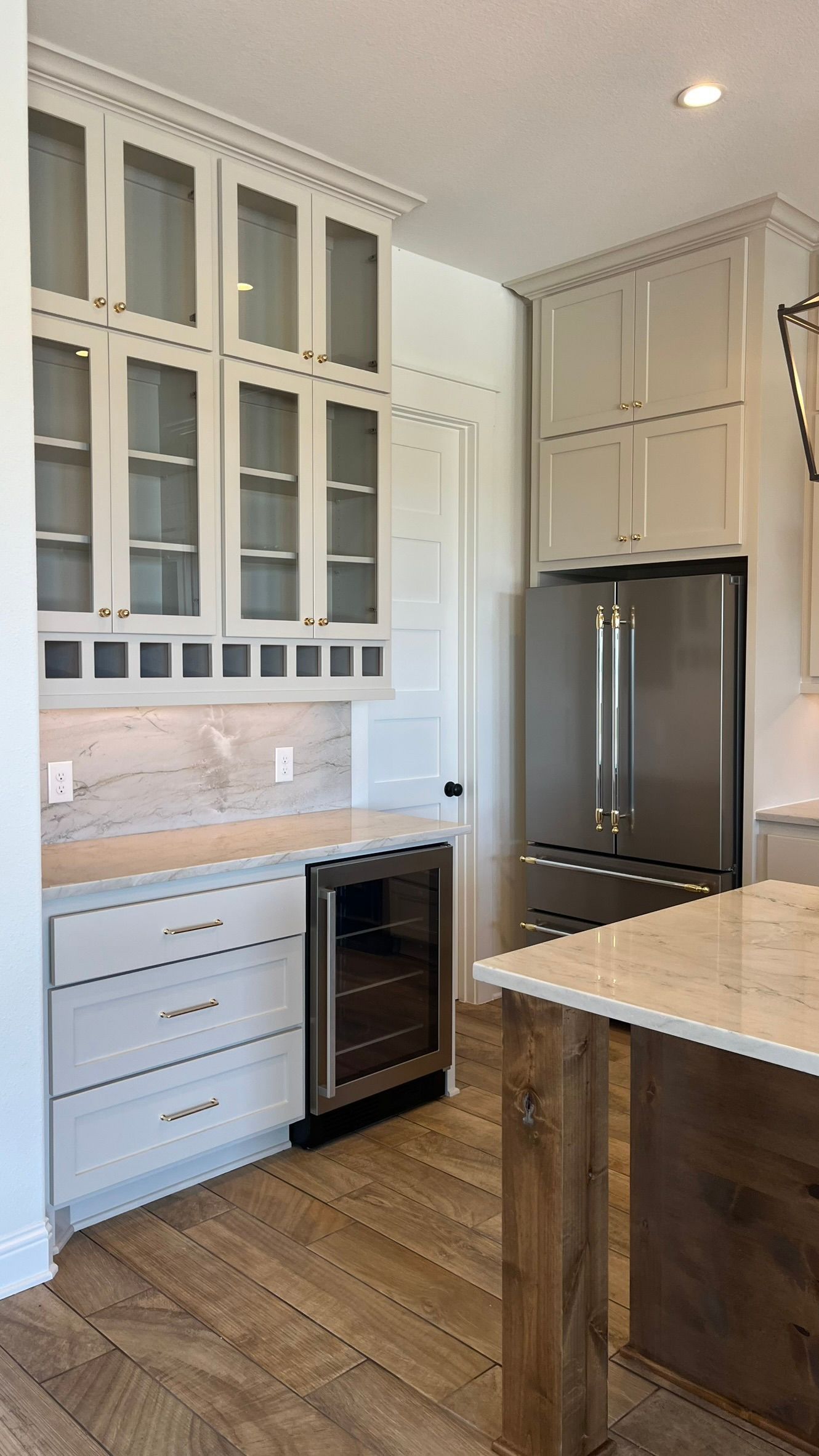 A kitchen with white cabinets, stainless steel appliances, and a wine cooler