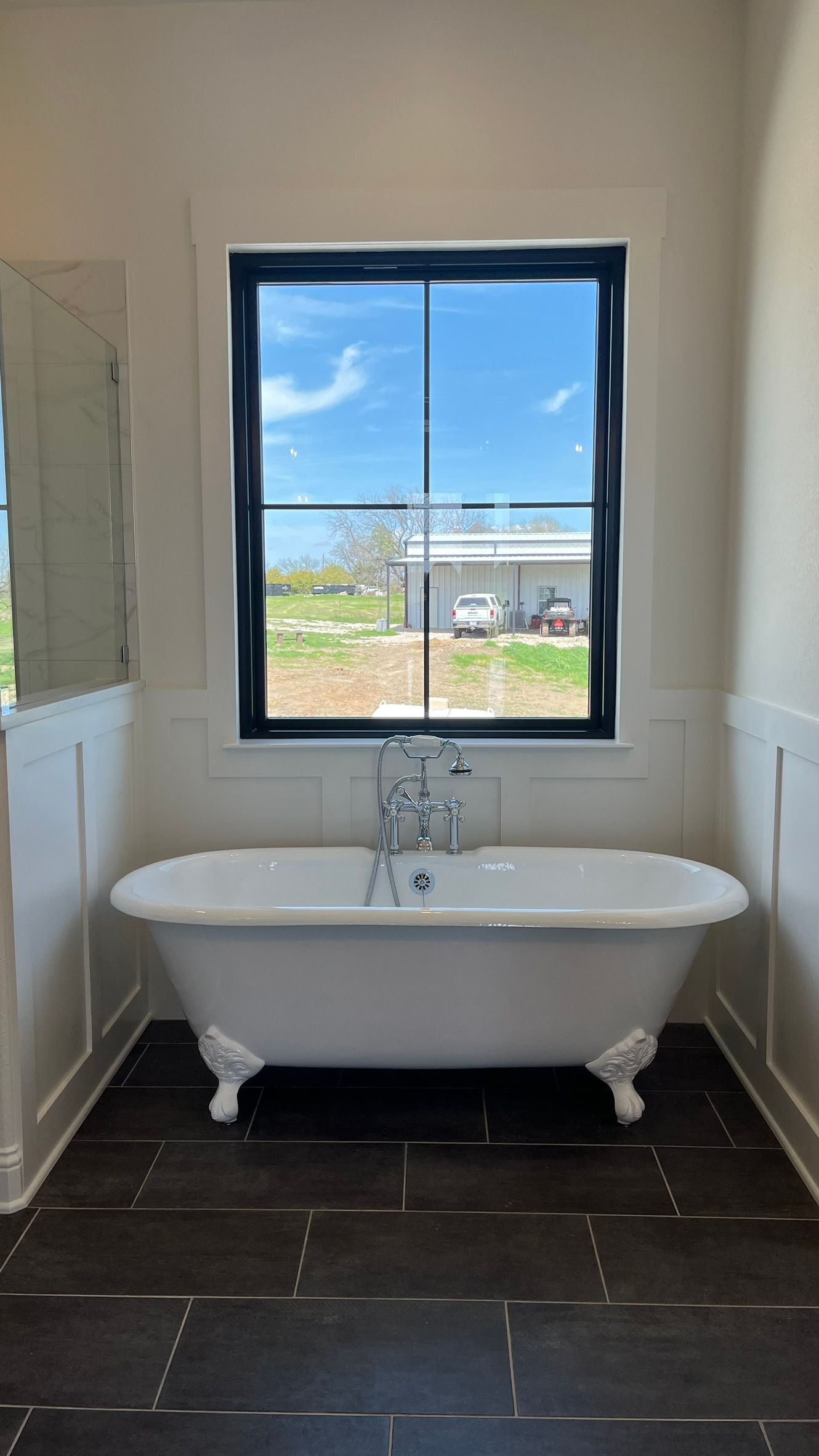 A bathroom with a bathtub and a window