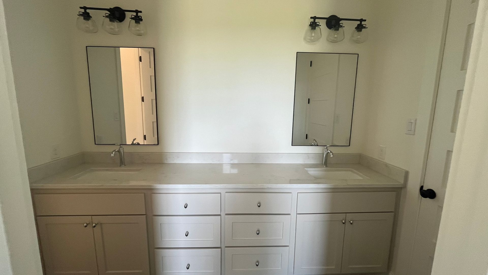 A bathroom with two sinks and two mirrors