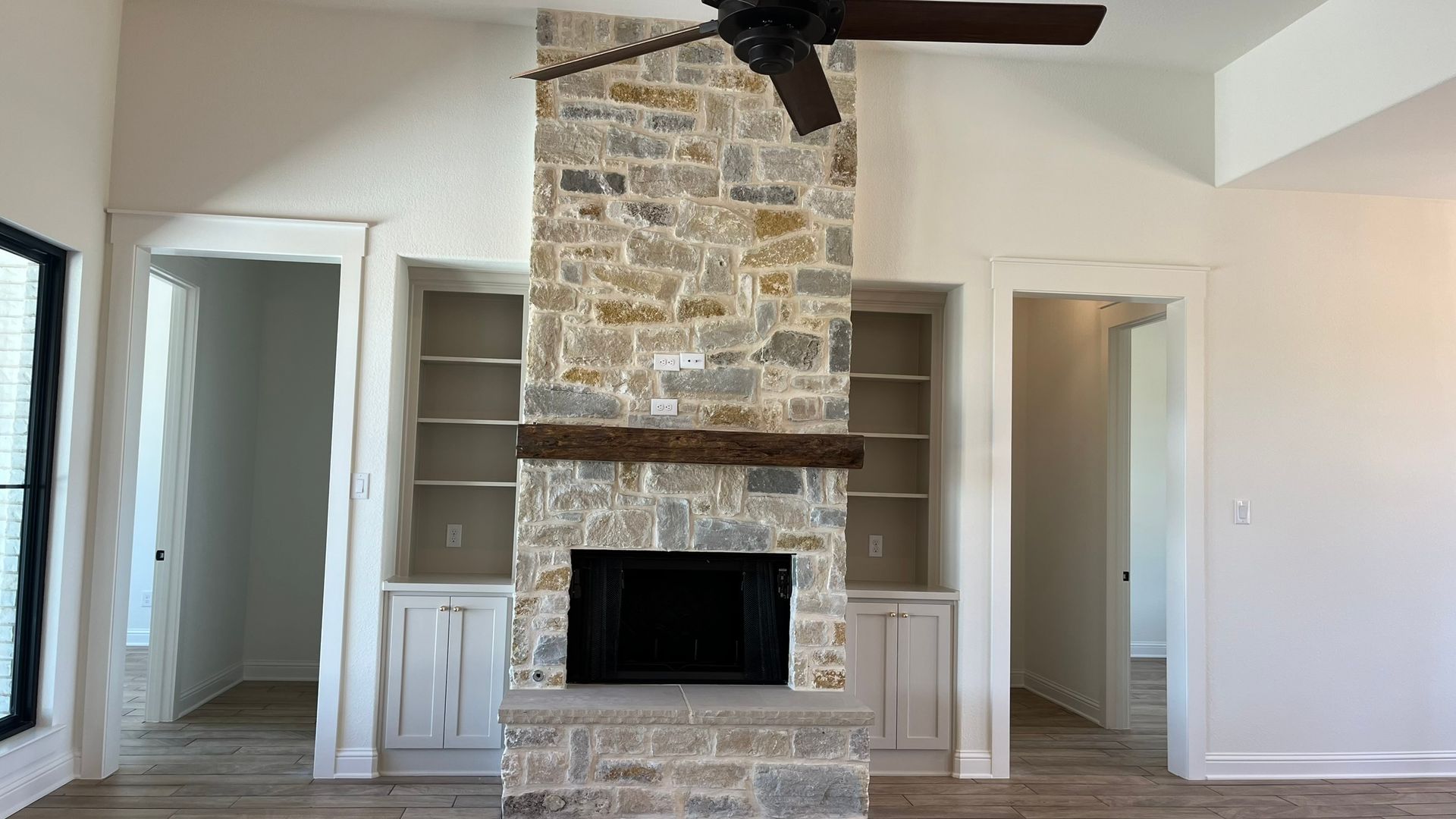 A living room with a fireplace and a ceiling fan