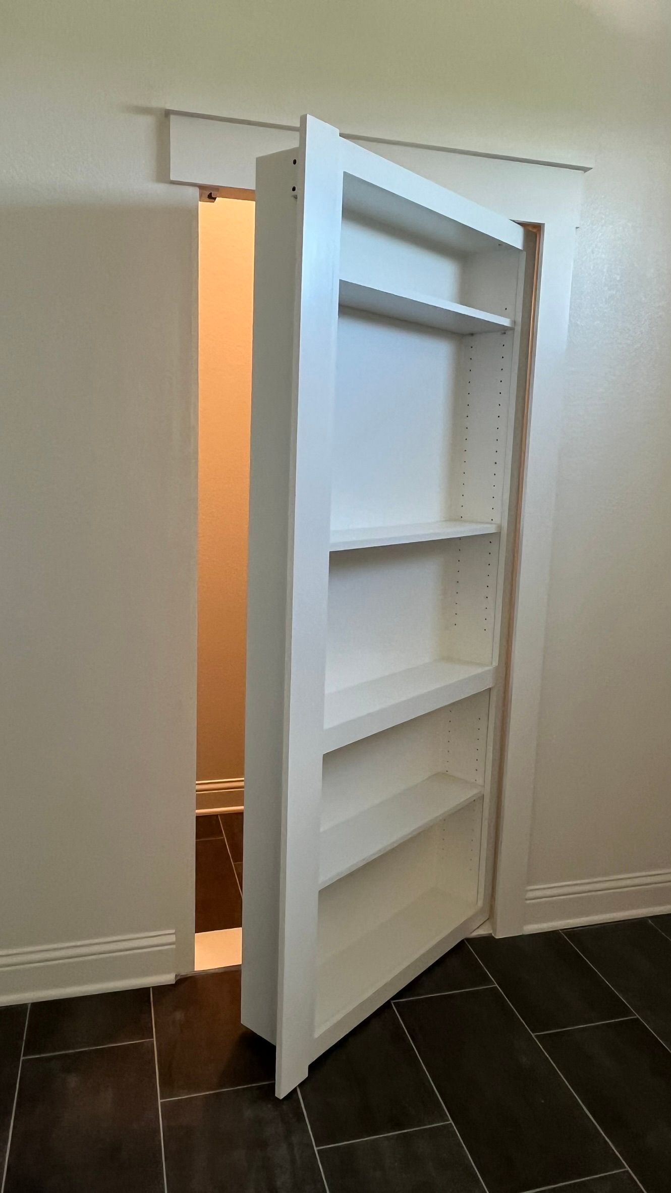 A hidden wardrobe room accessed through a bookshelf door
