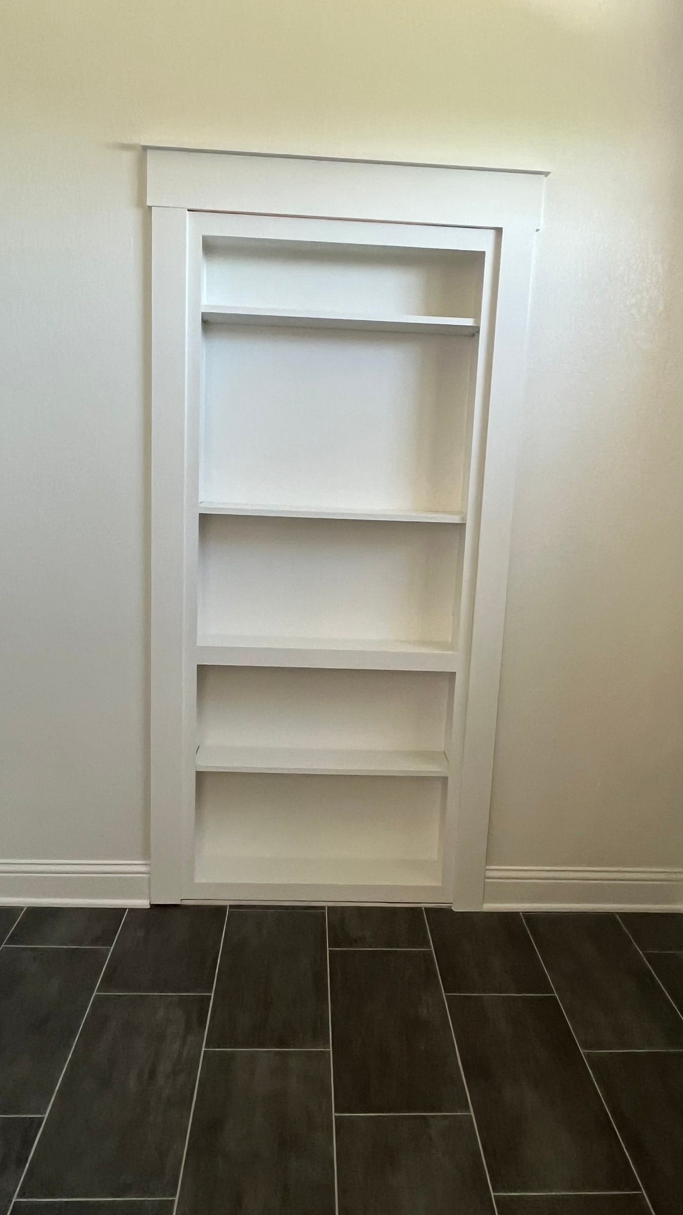A bookshelf door that leads to a wardrobe room