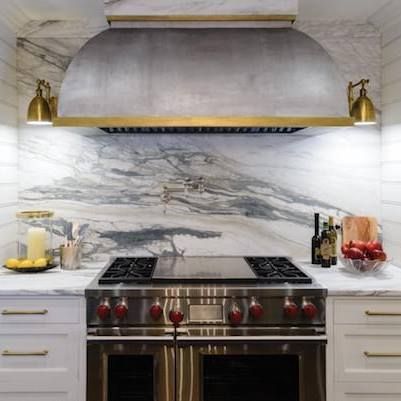 a kitchen with a stove top oven and a hood